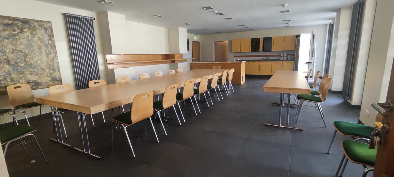 Die Saaltheke mit langer Tafel und Stühlen